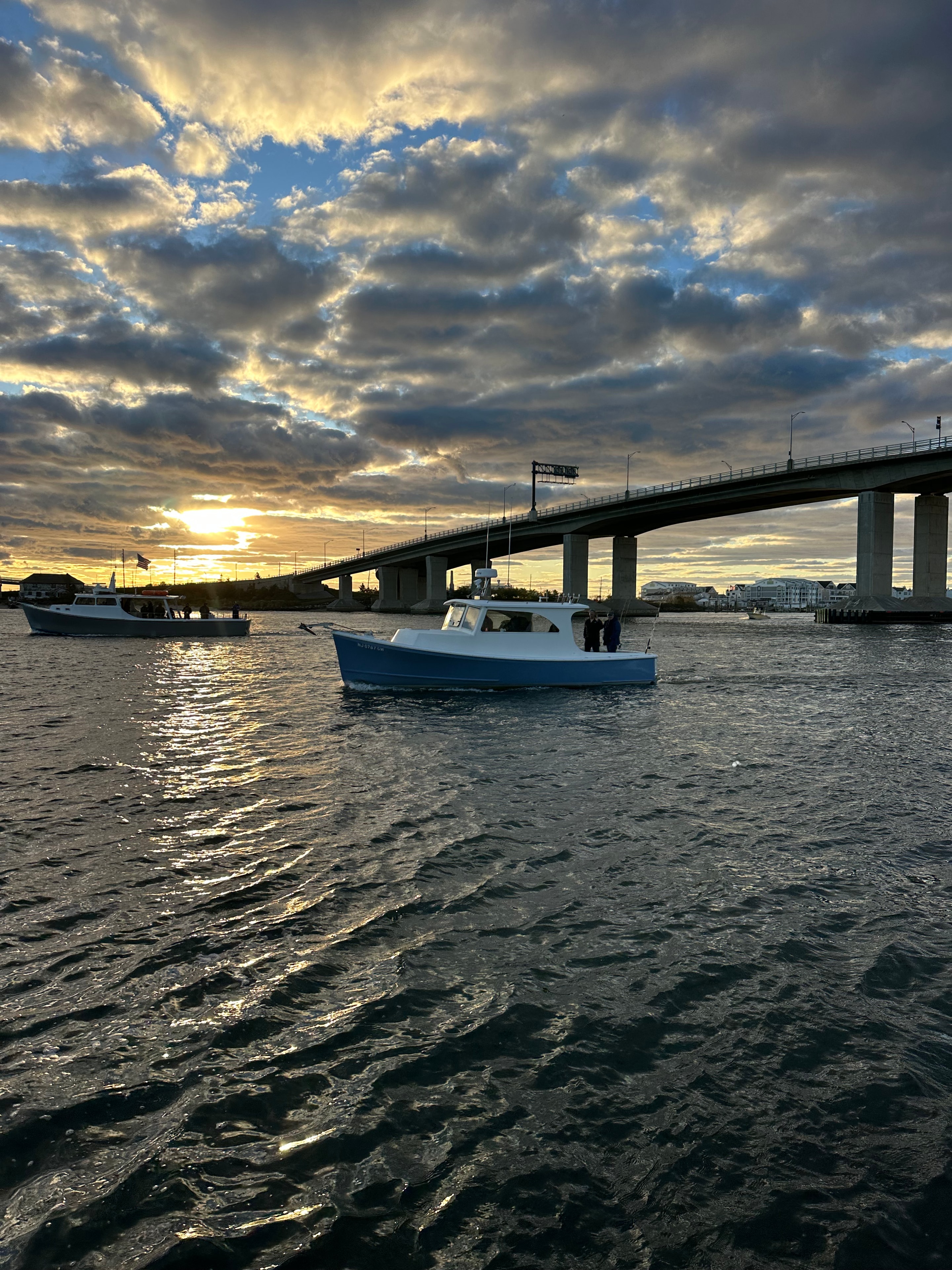Twin Lights Cup — fishing boats anchored under bridge at sunset